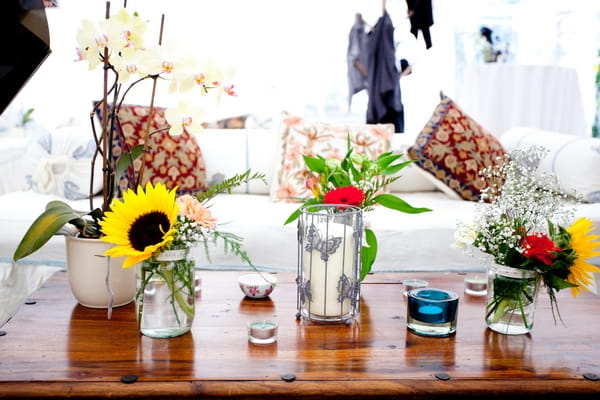 Jugs and vases of wedding flowers on table