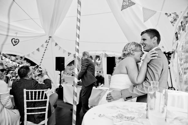 Bride and groom laughing at speech