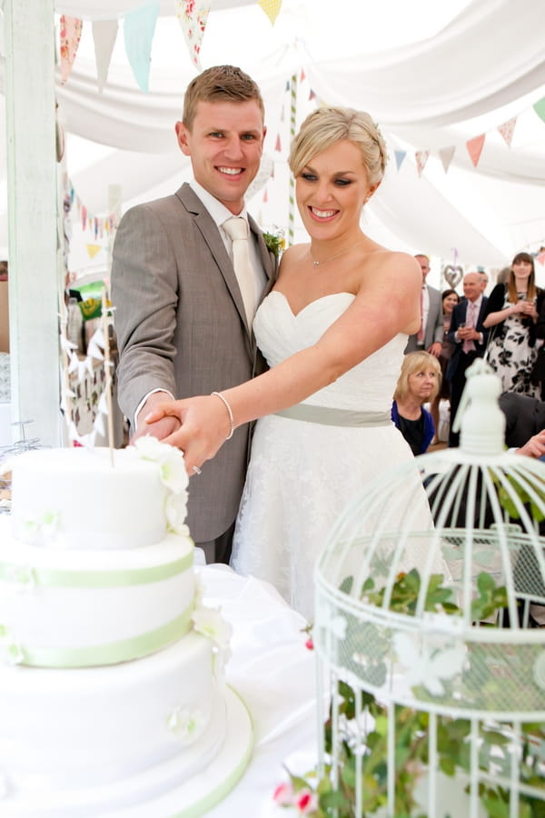 Bride and groom cutting wedding cake