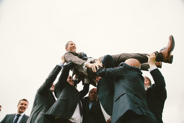 Groomsmen carrying groom