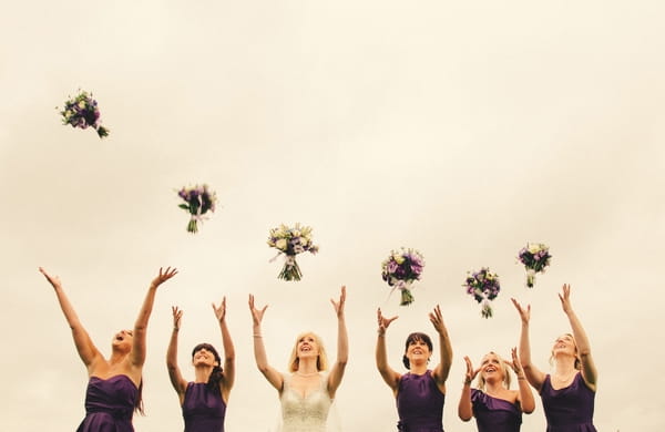 Bridesmaids throwing bouquets in the air