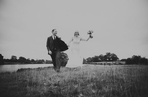 Bride and groom walking across field