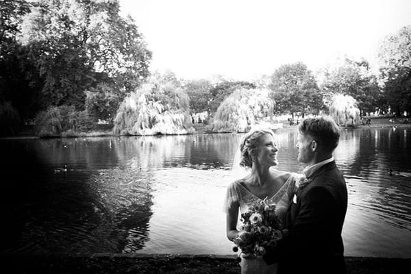 Bride and groom standing by lake