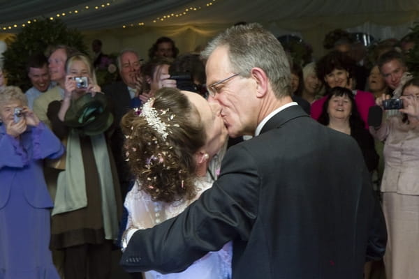 Bride and groom kiss on dancefloor