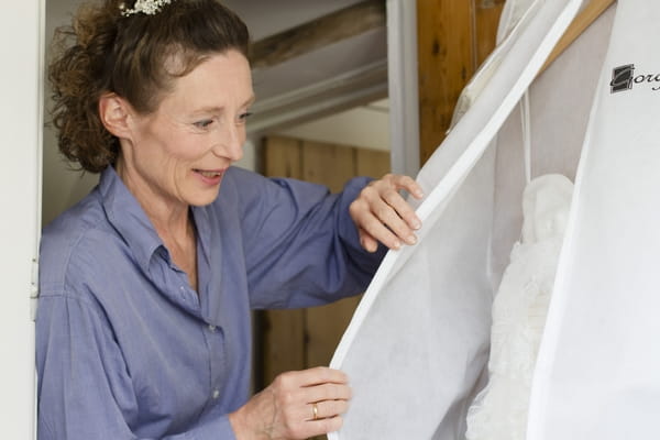 Bride taking cover off wedding dress