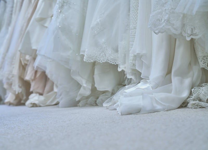 Rail of wedding dresses hanging on floor