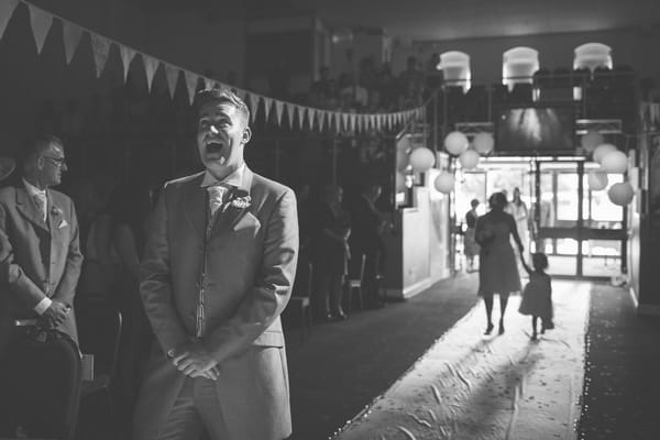 Groom pulling funny face waiting for bride