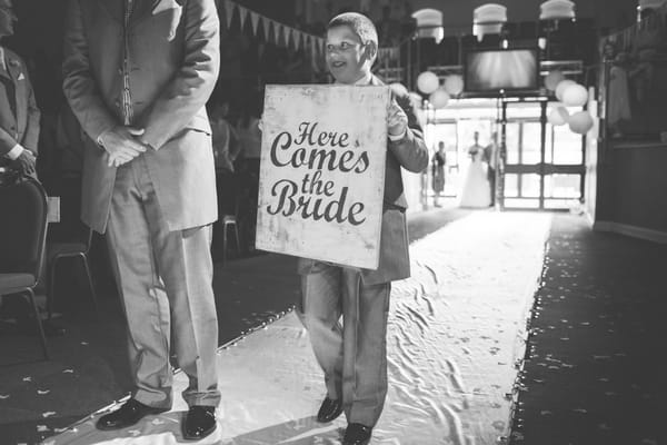 Boy carrying Here Comes the Bride sign