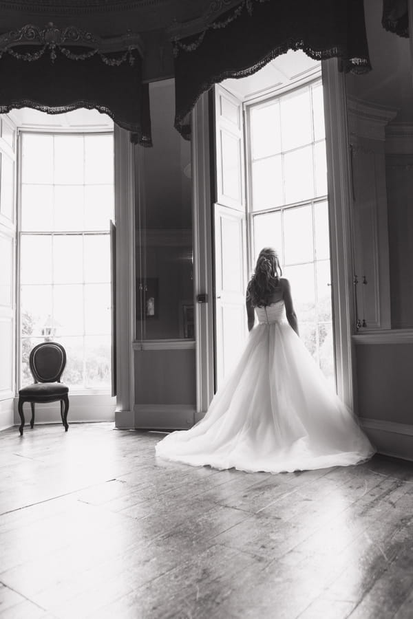 Bride looking out of tall window