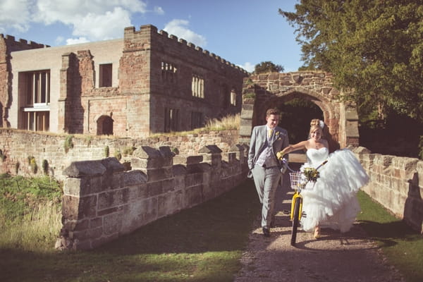 Bride and groom with yellow bike at Astley Castle