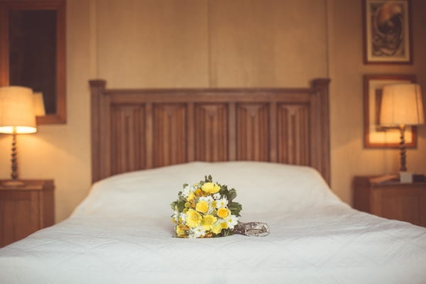 Yellow bridal bouquet on bed