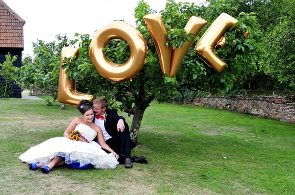 Bride and groom sitting under love letters