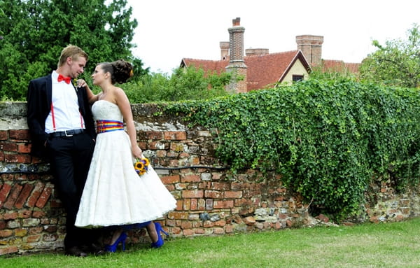 Bride and groom by wall