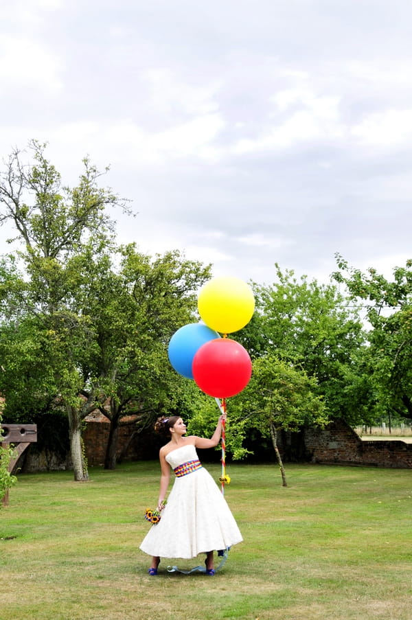 Bride holding coloured balloons