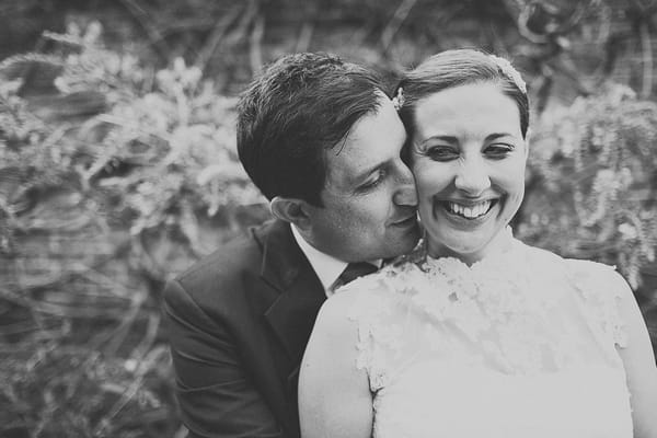 Groom kissing bride on cheek