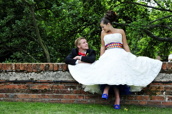 Bride sitting on wall