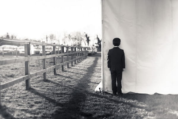 Small boy standing next to wedding marquee