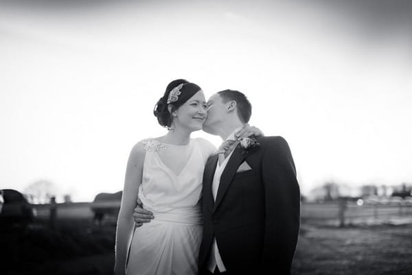 Groom kissing bride on cheek