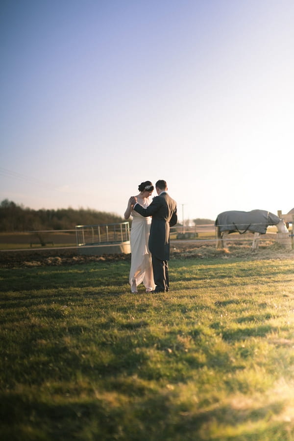 Groom with arm around bride