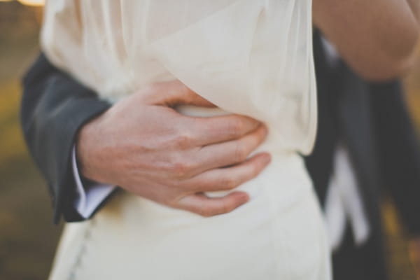 Groom's hand around bride's waist