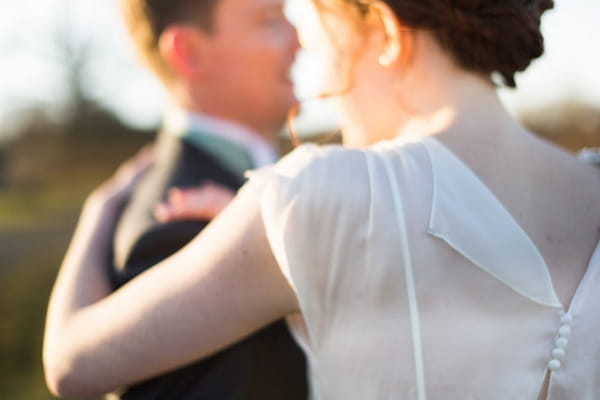 Bride's arm around groom