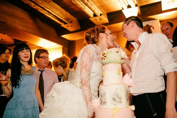 Groom feeding bride wedding cake