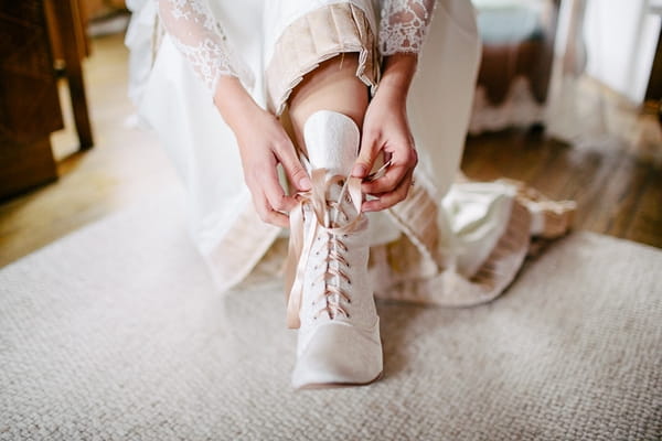 Bride putting on bridal boots