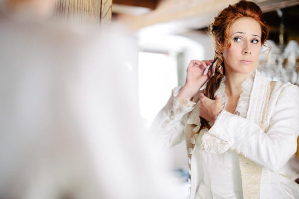 Bride adjusting hair in mirror