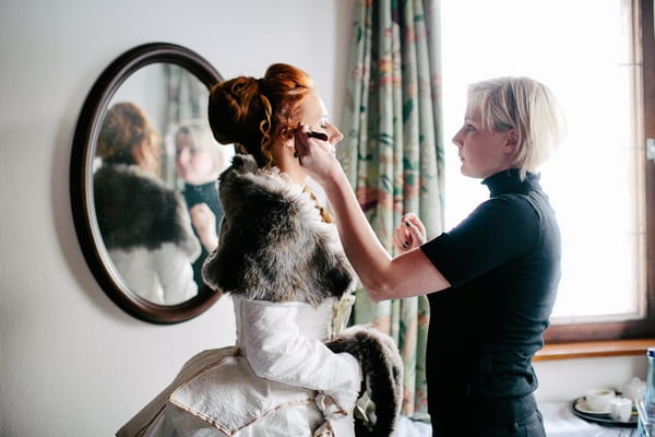 Bride having make-up applied