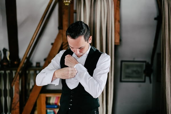 Groom putting on cufflink