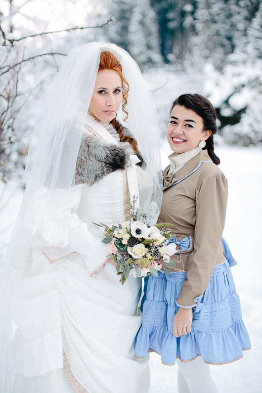 Bride and bridesmaid in snow