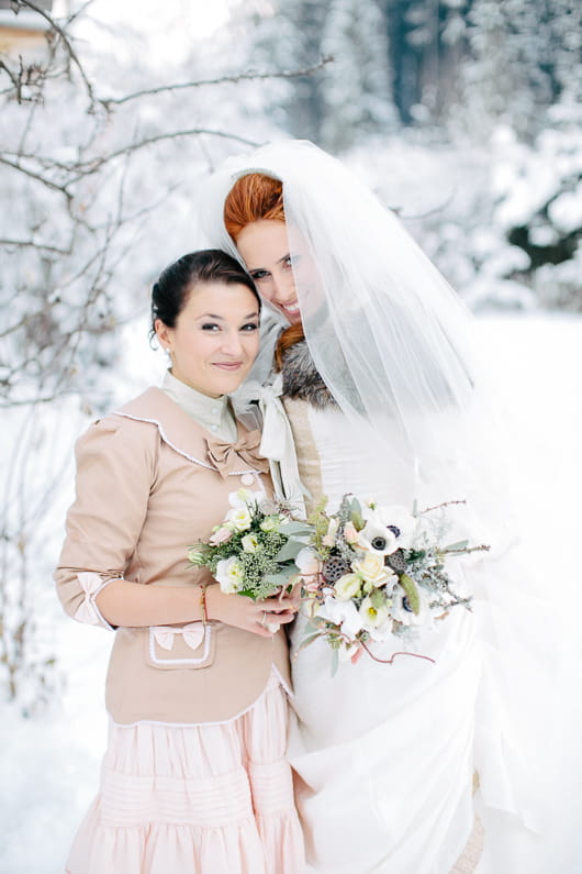 Bride and bridesmaid in snow