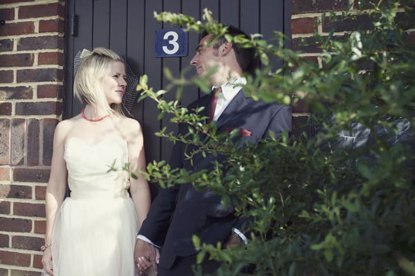 Bride and groom standing by door