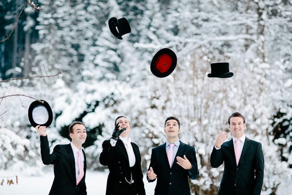 Groomsmen throwing top hats in air