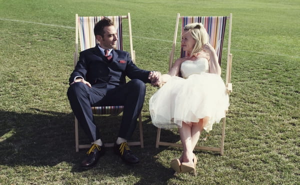 Bride and groom on deck chairs