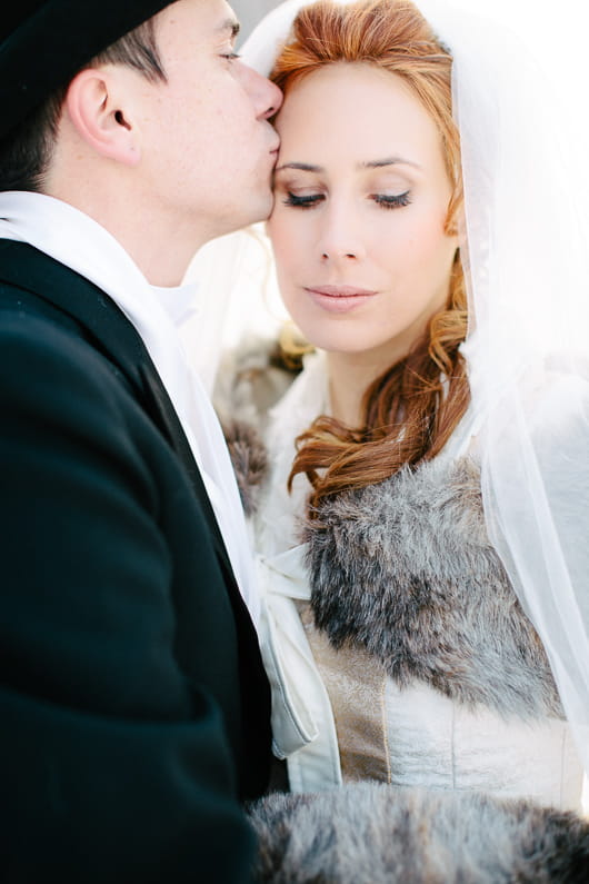 Groom kissing bride's head