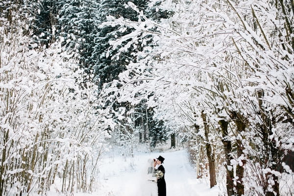 Bride and groom standing in snow