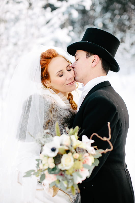 Groom kissing bride on cheek