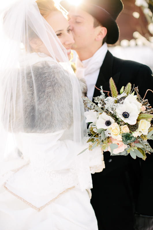 Groom kissing bride on cheek