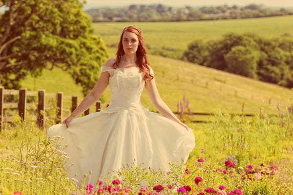 Vintage bride holding out dress