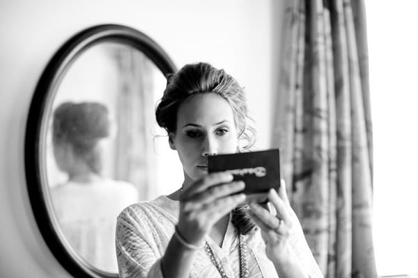 Bride looking at make-up in mirror