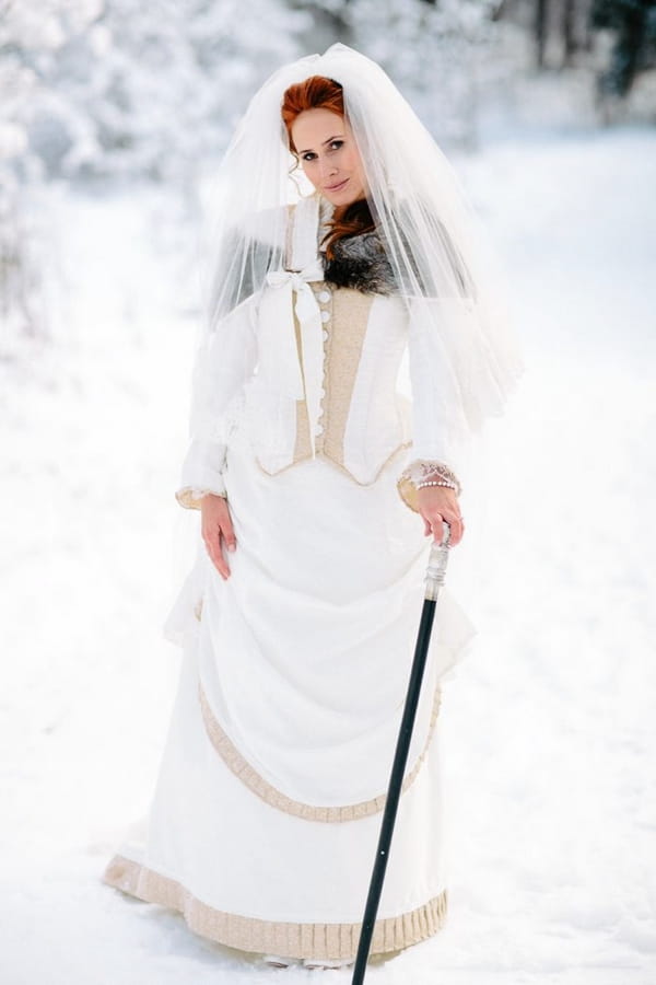 Bride in snow with groom's cane