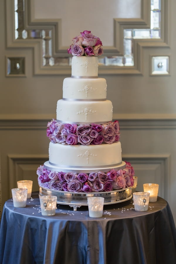 Tiered wedding cake with purple flowers