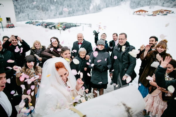 Bride being showered in confetti in snow