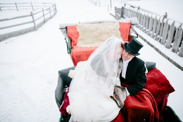 Bride and groom in back of horse and carriage