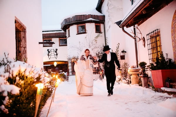 Bride and groom walking in snow