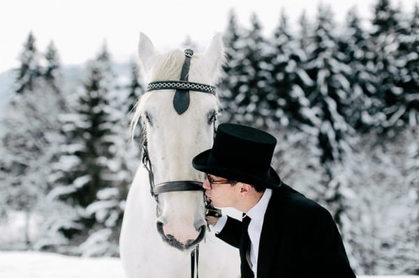 Groom kissing horse