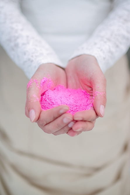 Bride holding pink holi powder