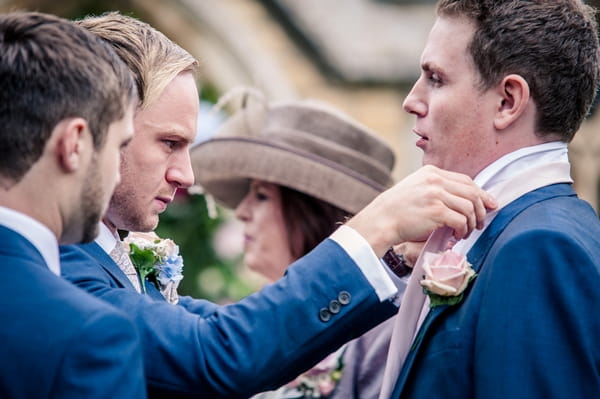 Groom adjusting best man's collar