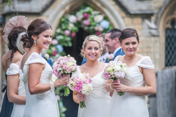 Bridesmaids holding bouquets outside church